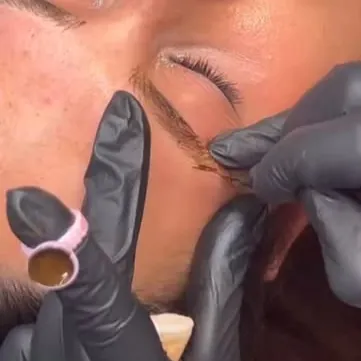 Liliya Lysa haciendo microblading de cejas a una clienta